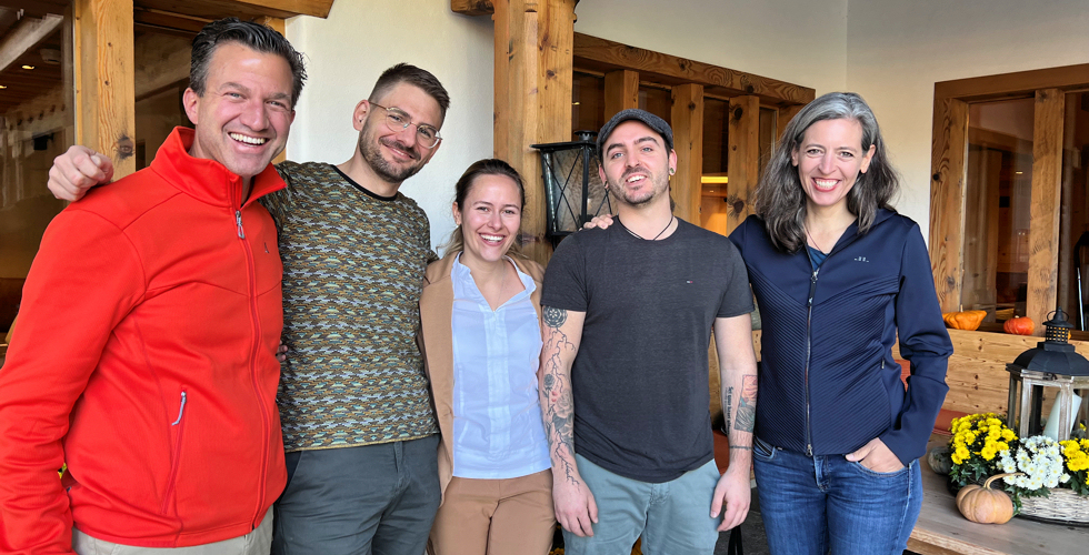 Zwei Männer und eine Frau vor einem Hoteleingang posierend