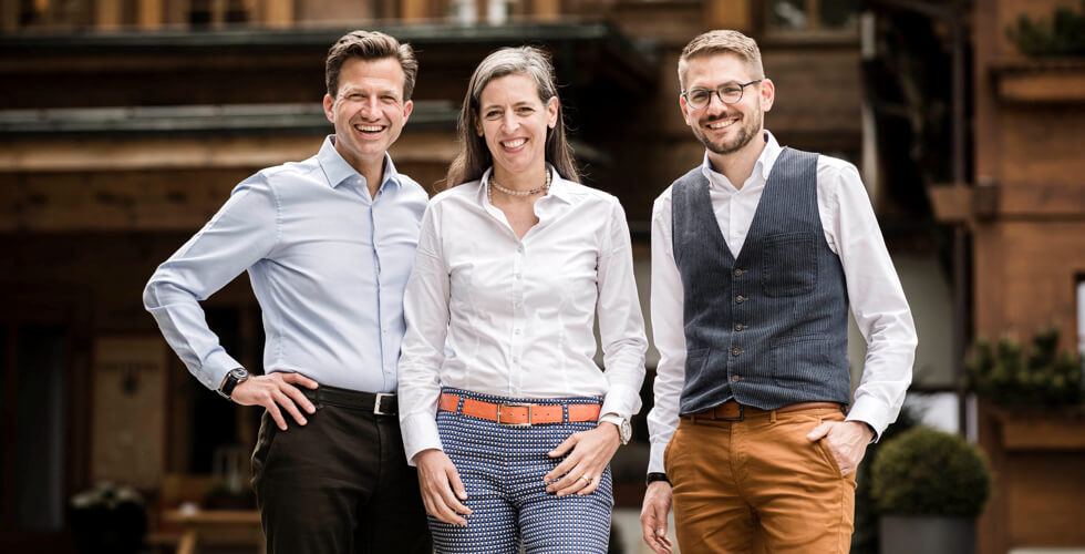 Vielseitigkeit, Kreativität und Sportlichkeit für MAISON HORNBERG - DANKE Manfred! 2 Zwei Männer und eine Frau vor einem Hoteleingang posierend